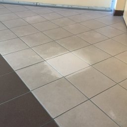 Czyściek - Umyta podłoga z płytek w dwóch odcieniach szarości, widoczna różnica w czystości między fragmentami podłogi.