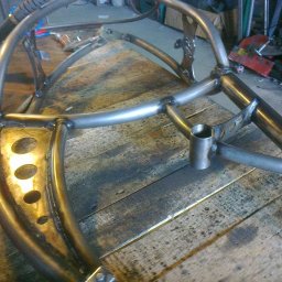 Alfa Welder - Metalowa konstrukcja spawana z rur i blach, z widocznymi śladami spawania i obróbki, leżąca na drewnianym stole warsztatowym.