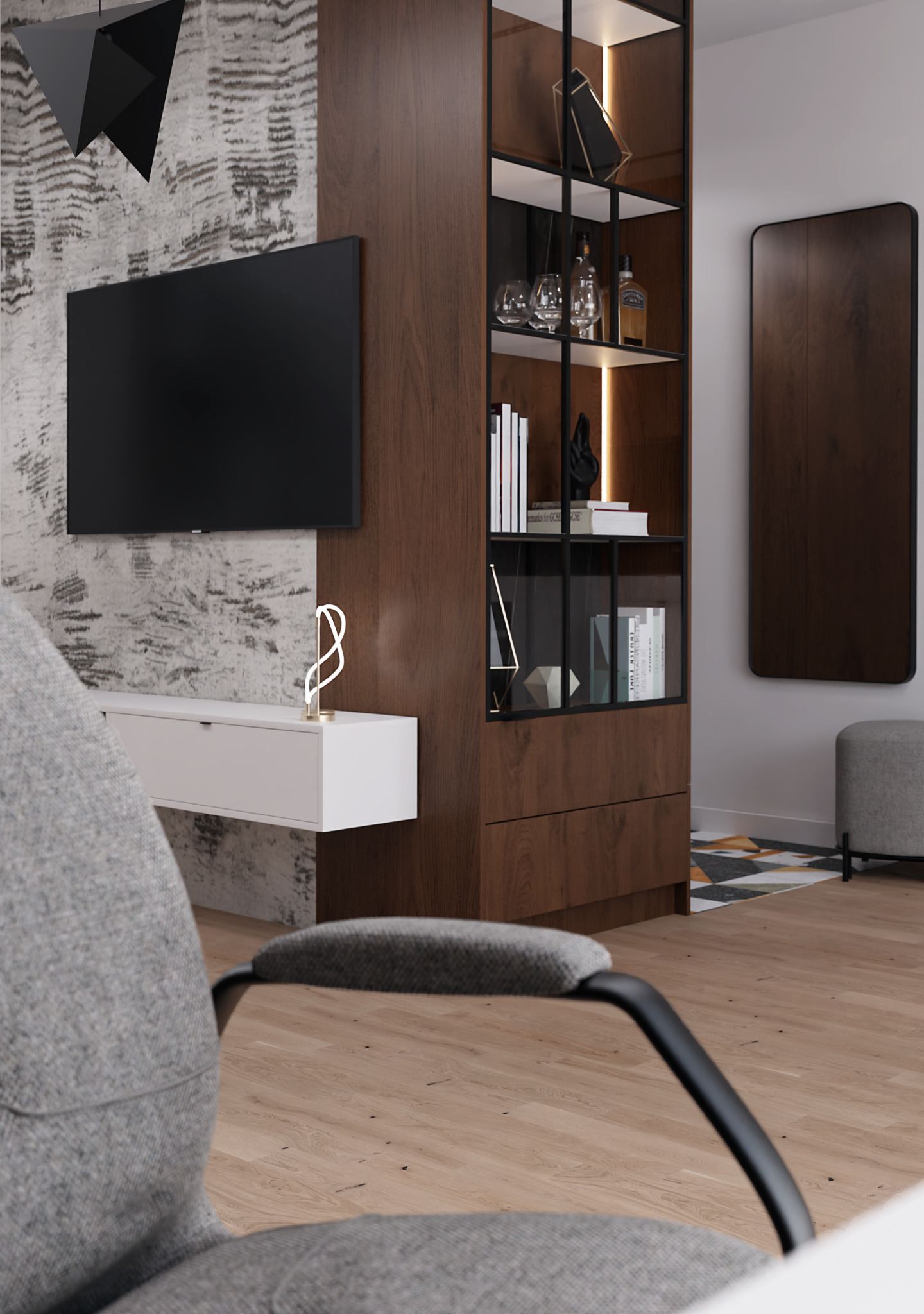 Nowoczesny salon w odcieniach szarości i brązu z telewizorem, szafką RTV z dekoracyjną lampką, regałem z podświetlanymi półkami i szarym pufem, widziany zza szarego fotela biurowego.