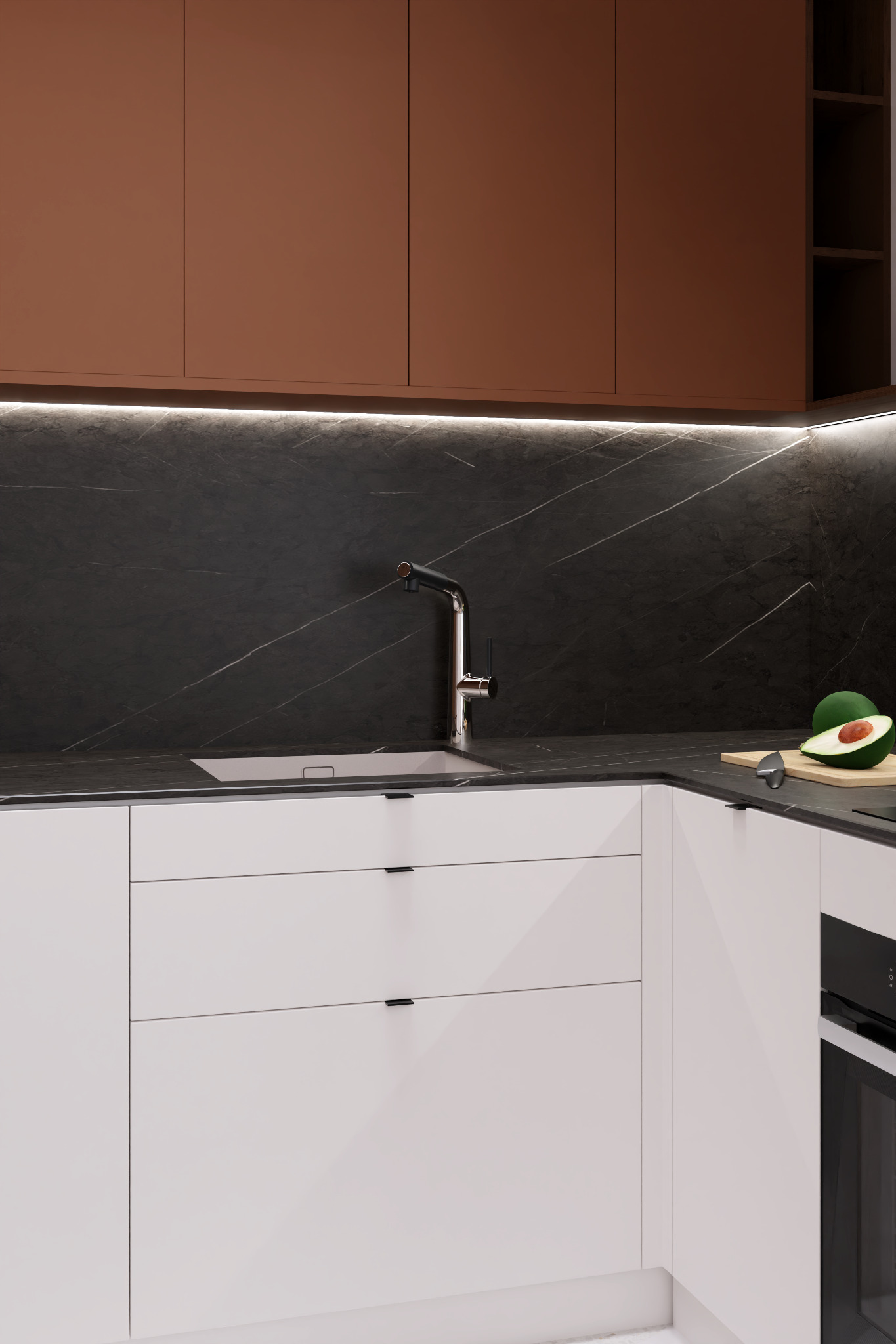 Minimalistyczna kuchnia: białe szafki dolne z czarnymi uchwytami, brązowe szafki górne, czarny blat z marmurowym wzorem, chromowana bateria, awokado na desce do krojenia. Realizacja w Rzeszowie.