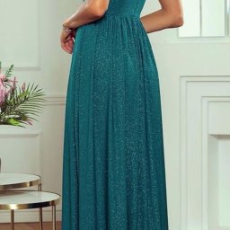 FHU Ewa Sobkowiak - Kobieta pozuje w długiej, błyszczącej, turkusowej sukni wieczorowej z głębokim dekoltem na plecach, widoczna z tyłu, z delikatnym makijażem i długimi kolczykami.