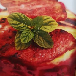 Marcelina Tomaja Grill Drive - Grillowana wołowina z sosem i świeżą miętą, zbliżenie na talerz z widocznymi śladami grillowania.