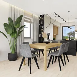 Jasna jadalnia z drewnianym stołem i szarymi krzesłami, okrągłe lampy wiszące, duża roślina doniczkowa, widok na kuchnię z czarną wyspą, nowoczesne oświetlenie punktowe.