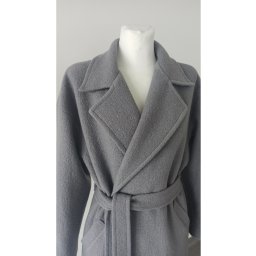 Szary wełniany płaszcz damski z paskiem, zaprezentowany na manekinie na tle białej ściany.