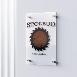 Logo firmy Stolbud na przezroczystej tablicy przymocowanej do ściany. Logo przedstawia piłę tarczową z przekrojem drewna w środku i napis 'Gwarancja jakości' pod spodem.