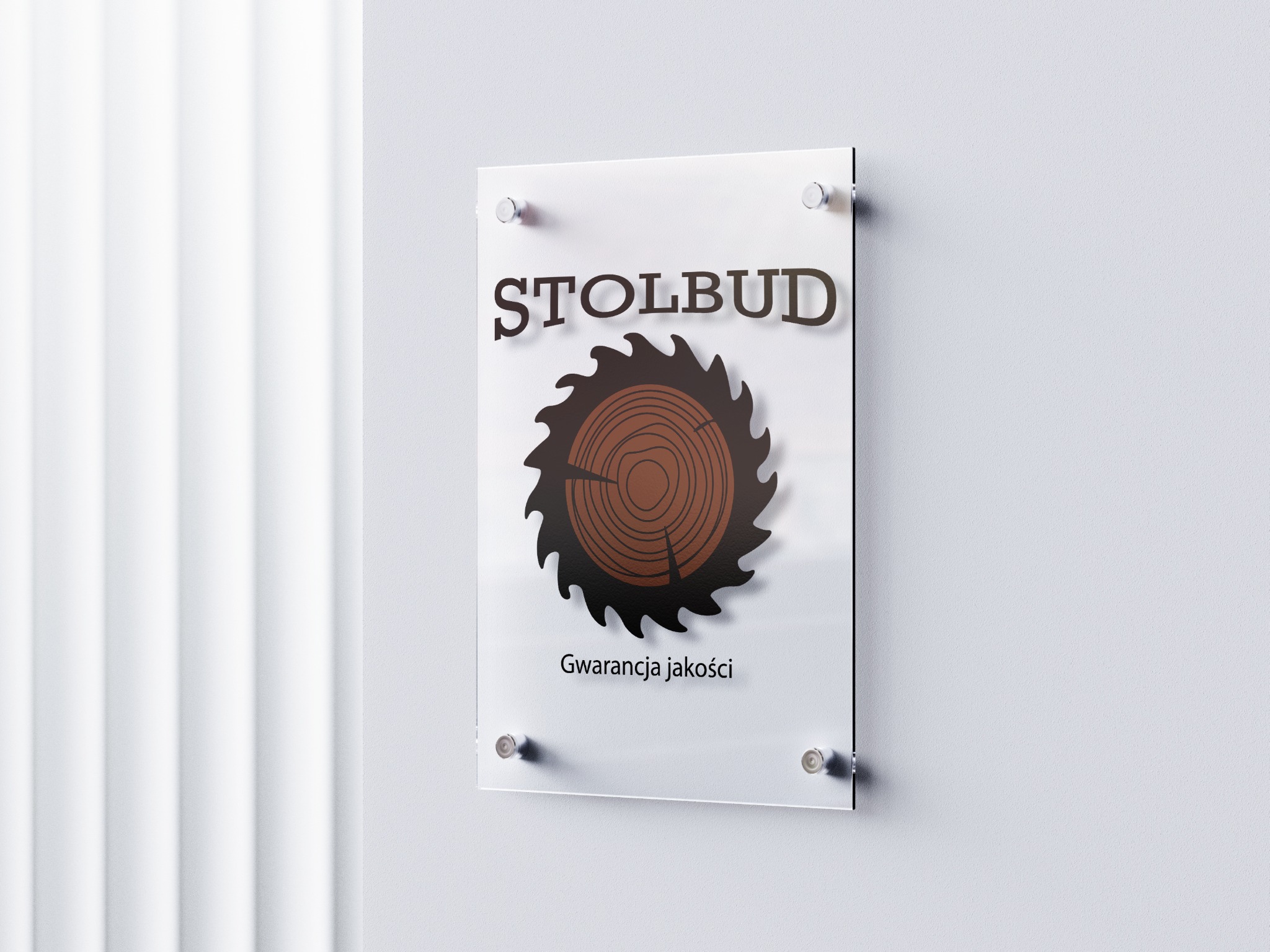 Logo firmy Stolbud na przezroczystej tablicy przymocowanej do ściany. Logo przedstawia piłę tarczową z przekrojem drewna w środku i napis 'Gwarancja jakości' pod spodem.
