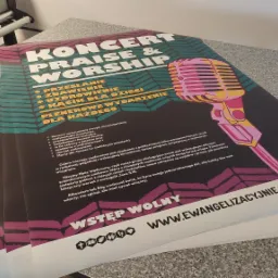 Stos plakatów z kolorową grafiką i tekstem informującym o koncercie muzyki chrześcijańskiej, ułożonych na szarym blacie, z elementami maszyny drukarskiej w tle.