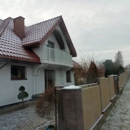 MAZO Creator - Nowoczesne ogrodzenie panelowe z elementami ceglanymi, w zimowej scenerii przed domem z białymi ścianami i brązowym dachem pokrytym śniegiem.