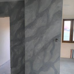 Mar Bud - Szara ściana z dekoracyjną fakturą w nowym wnętrzu. Widoczny fragment okna i instalacji. Świeżo wykończone ściany z unikalnym wzorem.