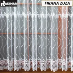 Delikatna, biała, woalowa firanka z dekoracyjnym wzorem w kropki i zawijasy, zawieszona na karniszu przed oknem.