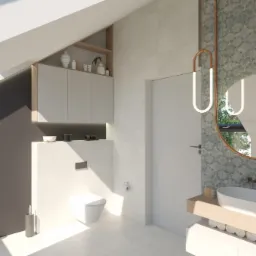 Jasna łazienka na poddaszu ze skośnym sufitem, z toaletą w zabudowie, szafkami wiszącymi i okrągłym lustrem z podświetleniem LED, umywalką nablatową i kabiną prysznicową ze szklanymi drzwiami.