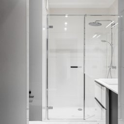 StudioRR MONIKA ROGOZIK-ROMANOWSKA - Nowoczesna łazienka w odcieniach szarości i bieli z kabiną prysznicową typu walk-in, umywalką z szafką i podwieszaną toaletą.