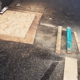 KMMJ Firma dekarska w Bielsku-Białej - Fragment dachu z deską OSB, świeżymi wiórami i piłą łańcuchową, widoczne także drewniane łatki, jedna pomalowana na turkusowo.