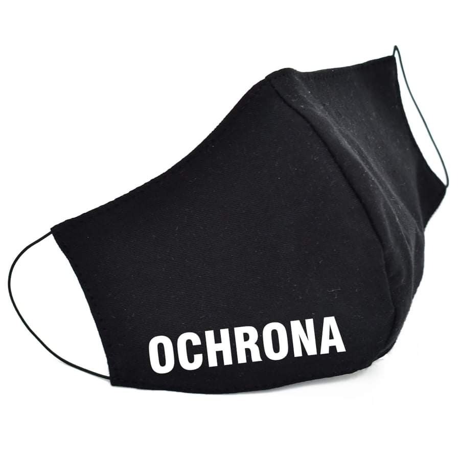 Czarna, materiałowa maska ochronna z białym napisem 'OCHRONA' leżąca na białym tle, widoczne gumki mocujące.