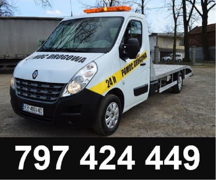 Biała laweta Renault z napisem 'Pomoc Drogowa 24h' i numerem telefonu na dole zdjęcia, zaparkowana na żwirowym podłożu przed budynkiem.