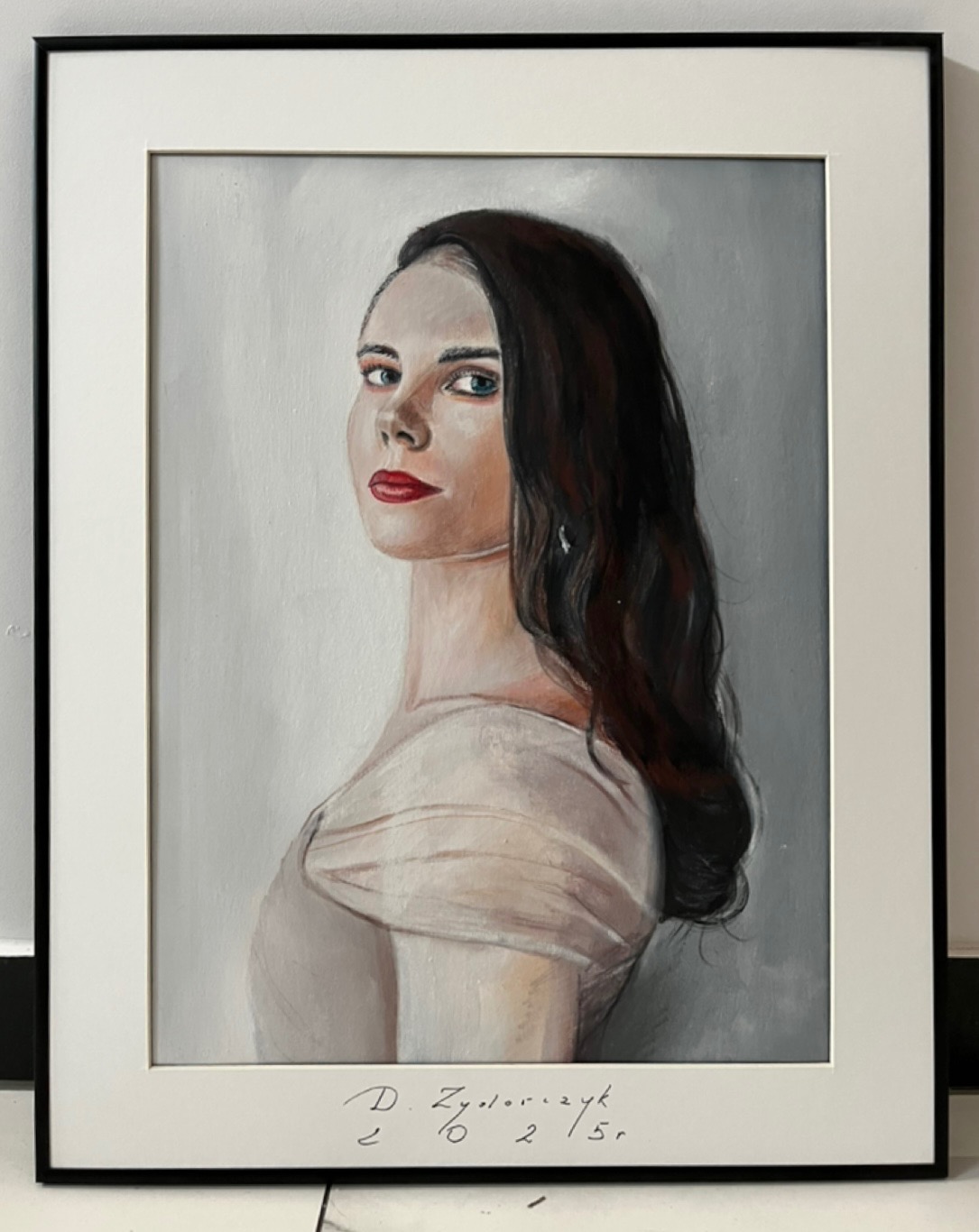 Oprawiony portret olejny kobiety z ciemnymi włosami, ubranej w jasną sukienkę, z sygnaturą artysty w dolnej części.