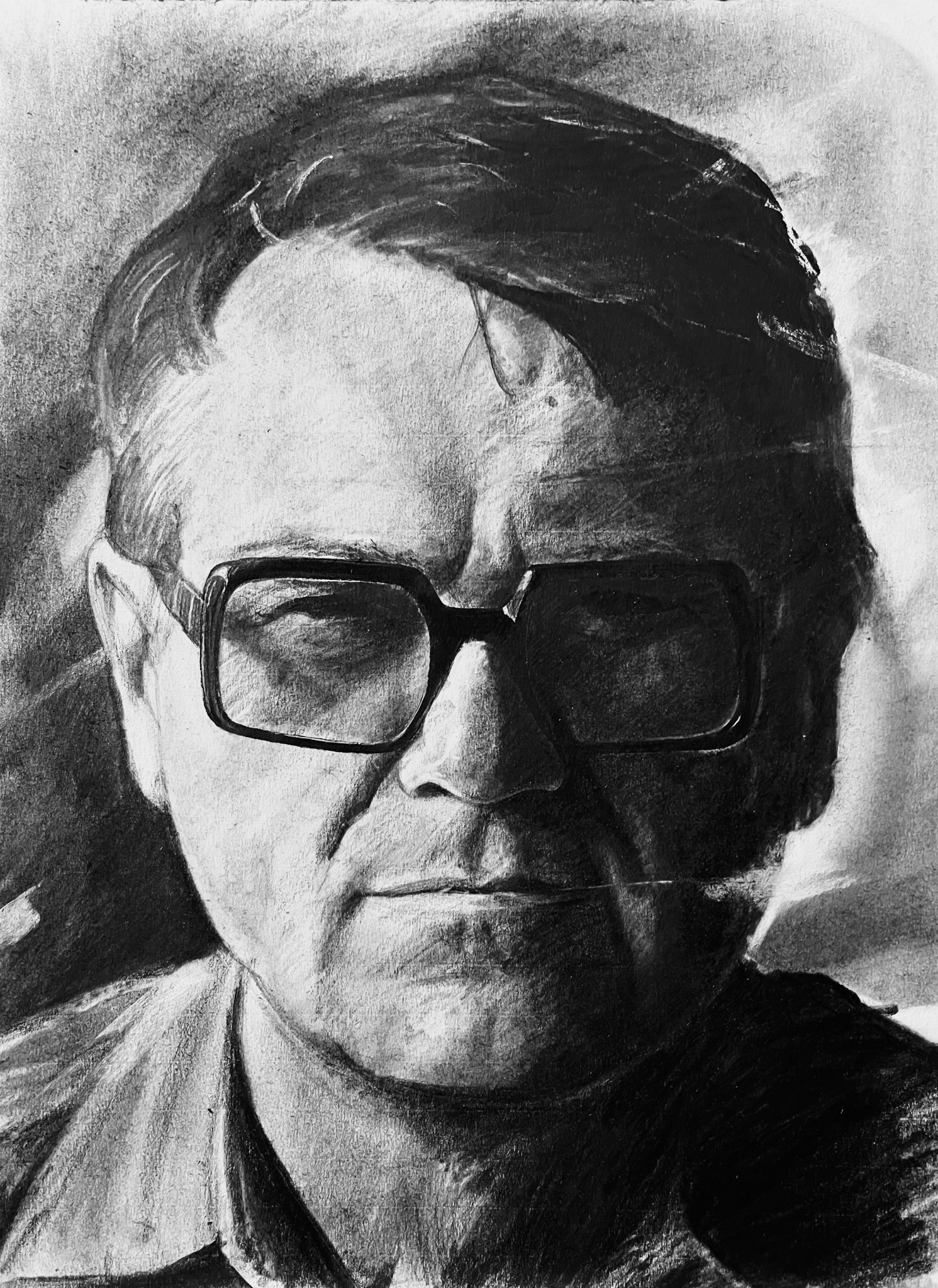Czarno-biały portret mężczyzny w okularach, wykonany techniką rysunku ołówkiem z widoczną fakturą papieru.