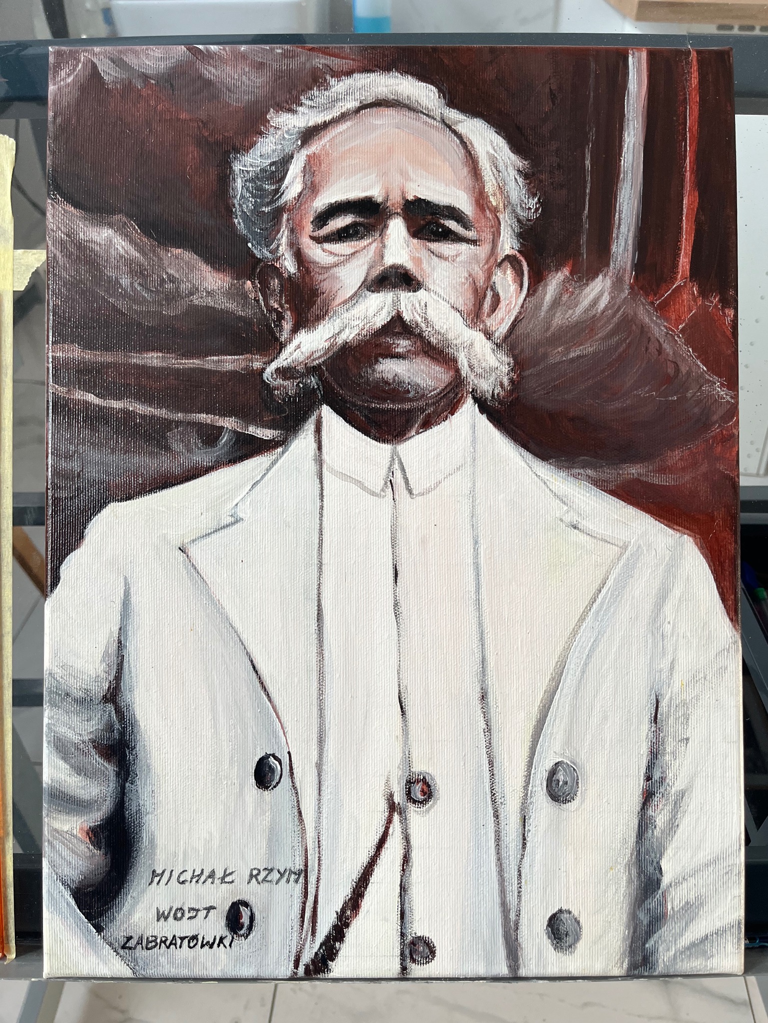 Portret olejny na płótnie przedstawiający mężczyznę z wąsami w białym garniturze na tle ciemnych zasłon, podpisany w lewym dolnym rogu.