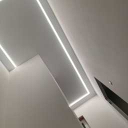 Reghome Sp. z o.o. - Nowoczesne oświetlenie sufitowe z liniowymi lampami LED w kształcie prostokąta, widok z dołu, minimalistyczny design.