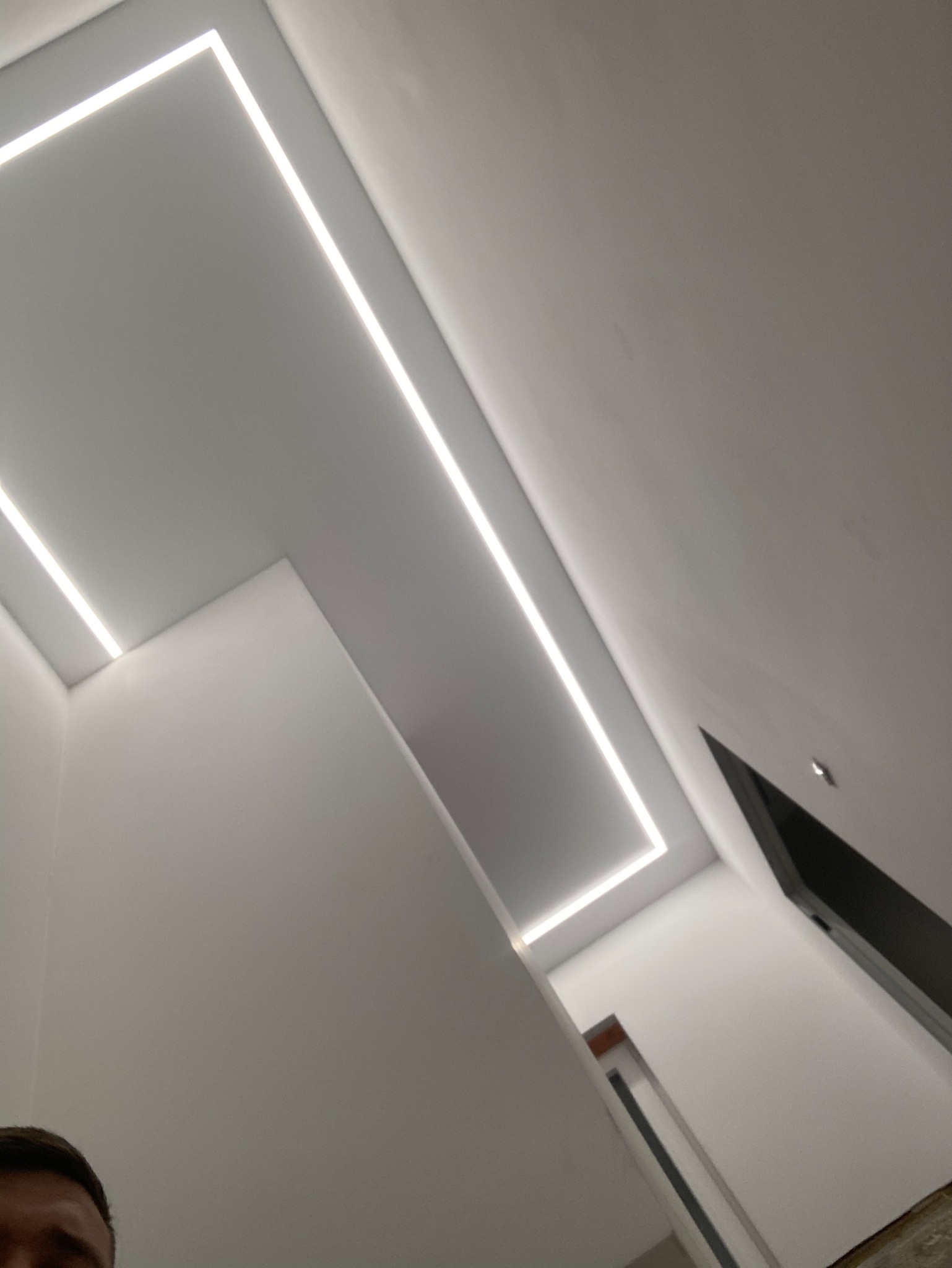 Nowoczesne oświetlenie sufitowe z liniowymi lampami LED w kształcie prostokąta, widok z dołu, minimalistyczny design.