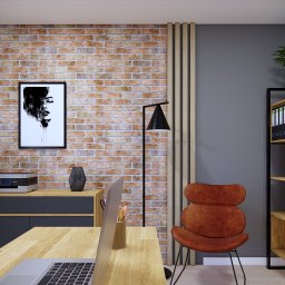 MSPROJEKT Michał Świerczek - Biuro w stylu industrialnym: ceglana ściana, czarna lampa, pomarańczowe krzesło, drewniany regał z segregatorami, biurko z laptopem. Nowoczesne i funkcjonalne.