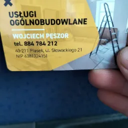 Wizytówka firmy Wojciech Pęszor Usługi Ogólnobudowlane z adresem i numerem telefonu, w tle fragment zdjęcia wnętrza z drabiną malarską.