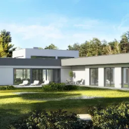 Nowoczesny parterowy dom z płaskim dachem, dużymi oknami przesuwnymi i tarasem z leżakami, otoczony zielonym trawnikiem i drzewami w słoneczny dzień.