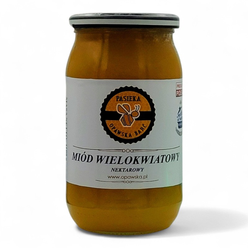 Słoik wielokwiatowego nektarowego z Pasieki Opawska Barć na białym tle. Widoczna etykieta z logo i nazwą produktu. Całość w ciepłej, miodowej tonacji.