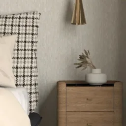 Sypialnia z tapicerowanym zagłówkiem w pepitkę, drewnianą szafką nocną z czarnym blatem i złotą lampą wiszącą w kształcie stożka.