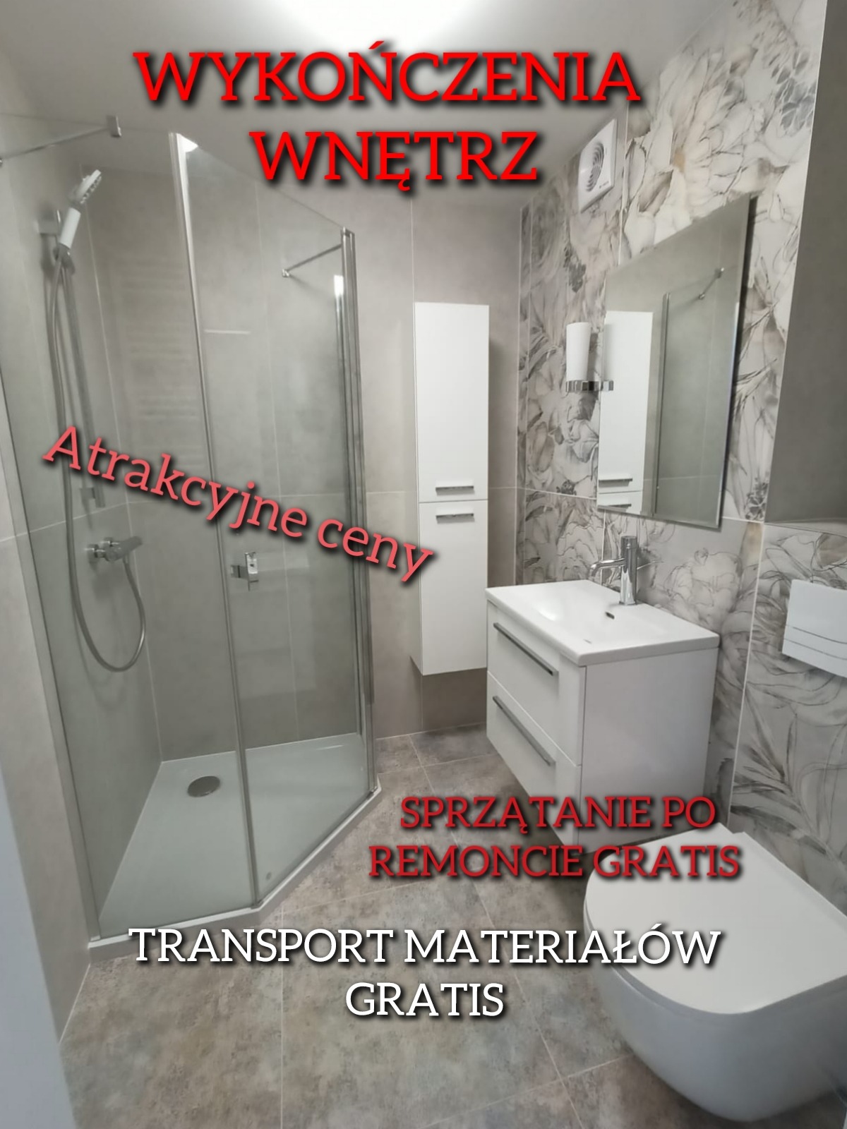 Wykończona łazienka z kabiną prysznicową, szafką z umywalką i toaletą, wykończona płytkami w odcieniach szarości i bieli, z dekoracyjną tapetą na jednej ze ścian. Na zdjęciu widoczne napisy reklamowe.