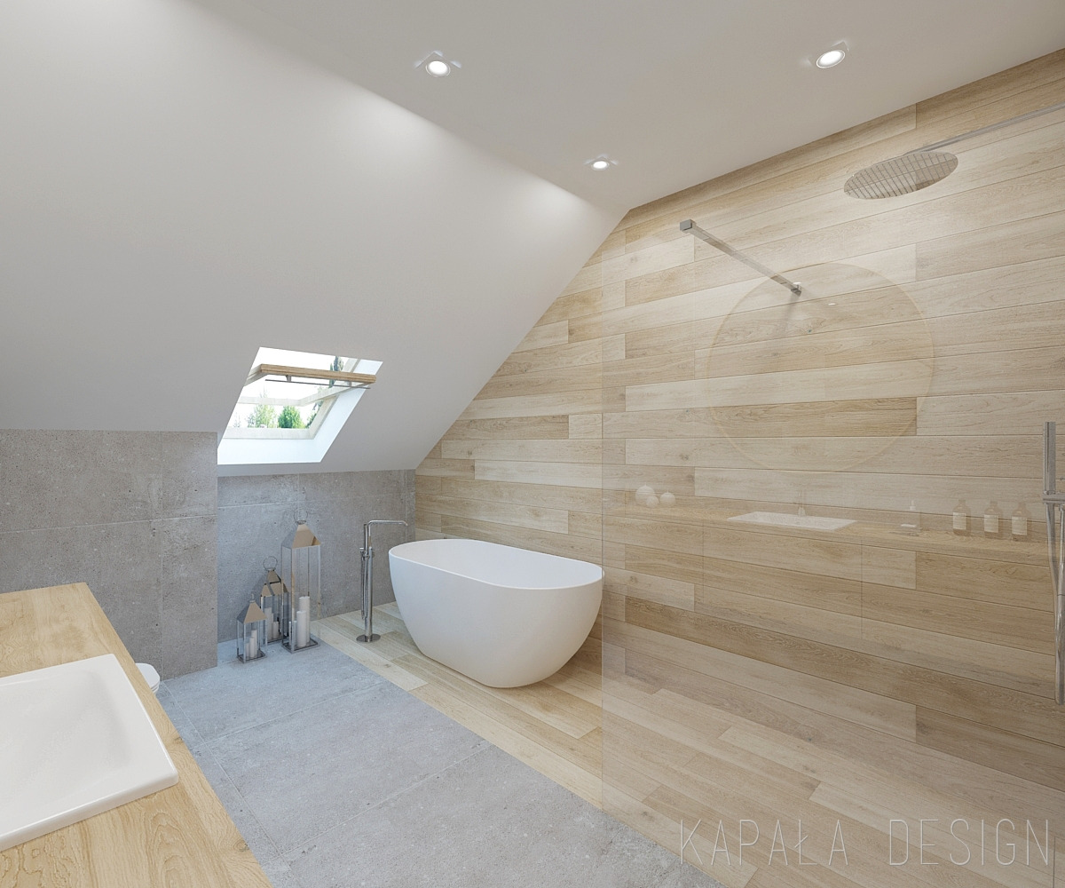 Jasna łazienka na poddaszu z wolnostojącą wanną, drewnopodobnymi płytkami na ścianie i suficie oraz oknem dachowym w skosie.