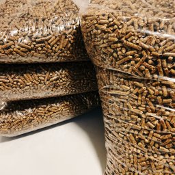 KMMOBILI Krystian Miętka - Ułożone worki z pelletem drzewnym, widoczne przez przezroczyste opakowanie, na białym tle.