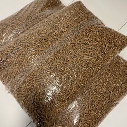 KMMOBILI Krystian Miętka - Dwa przezroczyste worki wypełnione brązowymi, drobnymi granulkami na białym tle, prawdopodobnie paliwo ekologiczne.