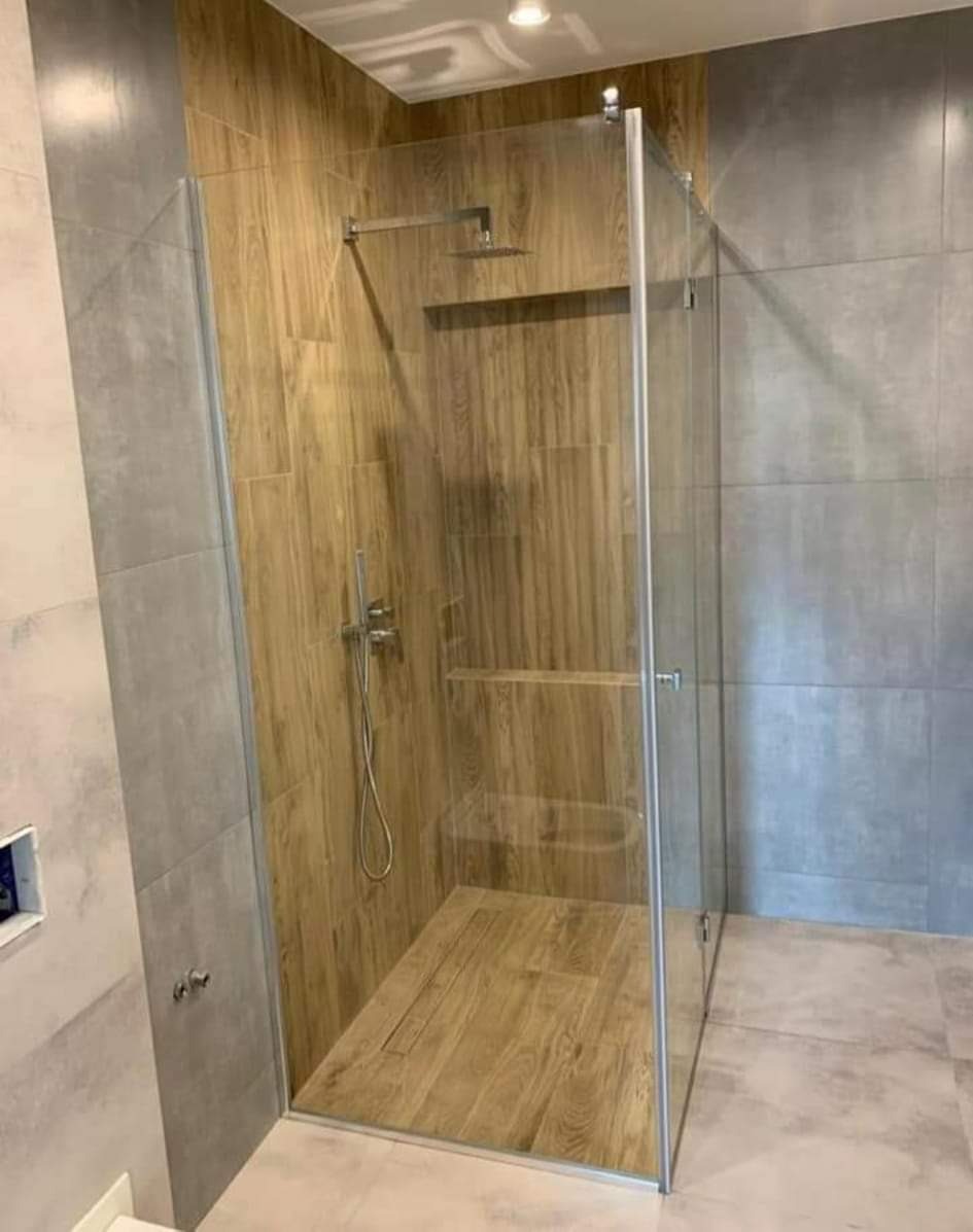 Kabina prysznicowa walk-in z drewnopodobnymi płytkami wewnątrz, szara ściana z boku, Olsztyn.