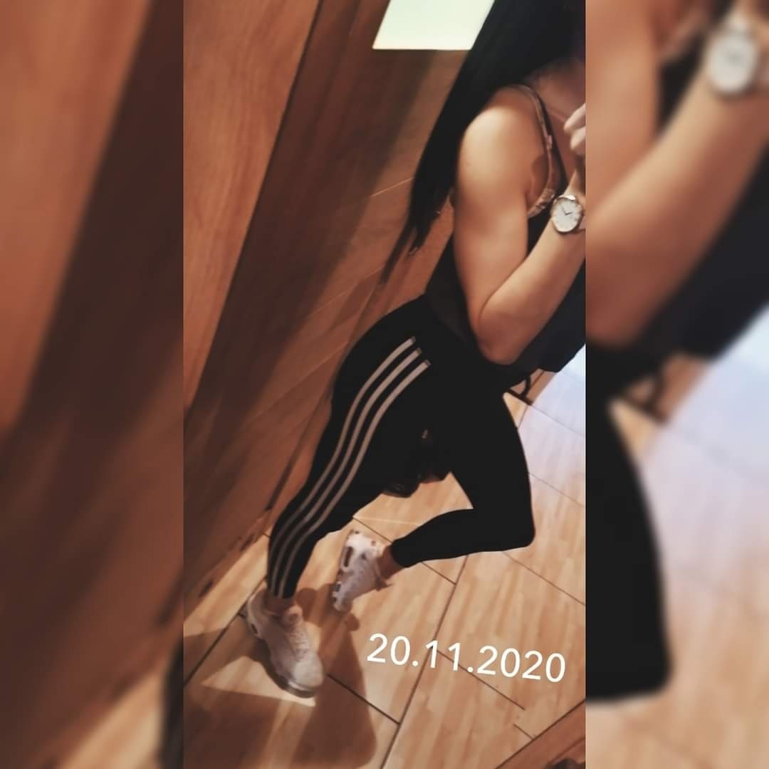 Kobieta w sportowym stroju (czarne legginsy z białymi paskami i top) oraz białych butach, pozująca do zdjęcia w Kołobrzegu. Na nadgarstku widoczny zegarek. Data 20.11.2020 na zdjęciu.