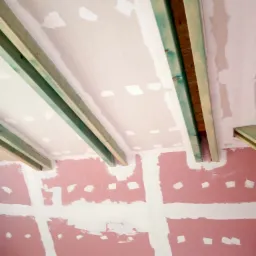 Ściana i sufit w trakcie przygotowywania do gładzi, widoczne profile drewniane i płyty kartonowo-gipsowe z widocznymi łączeniami.