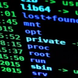 Ekran monitora z wyświetlonymi zielonymi liniami kodu, prezentujący zawartość katalogu z datami i nazwami plików, w tym 'private -> /home/encrypted'.