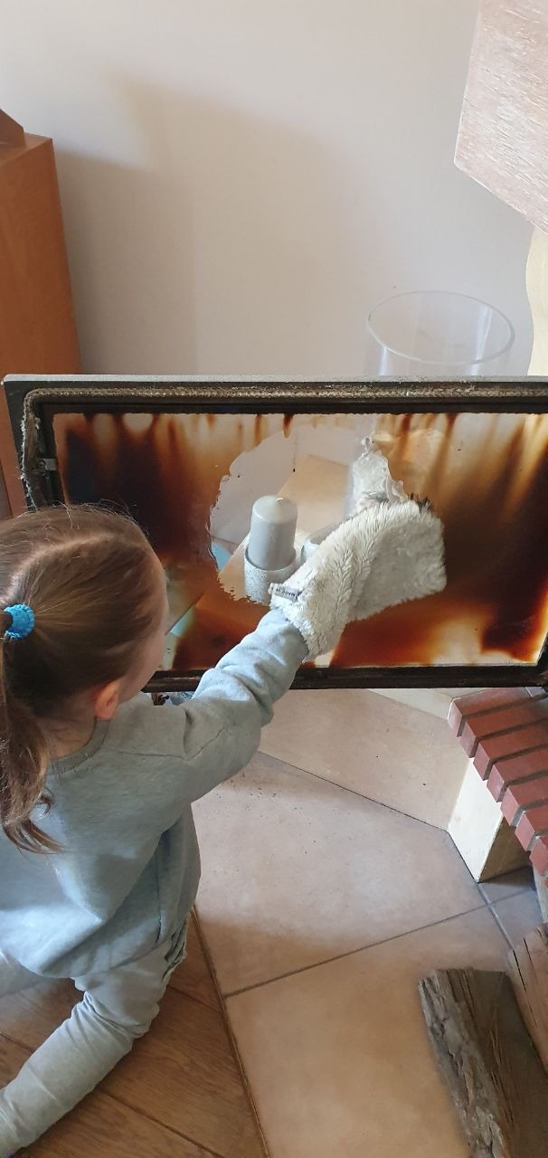 Szyba kominkowa czyszczona białą rękawicą z samą wodą bez środków chemicznych.