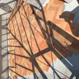 PROFESTON - Układanie ceglanej podłogi w jodełkę w Częstochowie, widoczne ostre cienie rzucane przez konstrukcję, narzędzie leżące na cegłach i fragmenty niezakończonych prac.