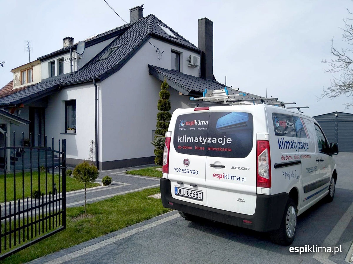 Biały samochód dostawczy firmy Espiklima z drabiną na dachu, zaparkowany przed domem z zamontowanym klimatyzatorem na ścianie.