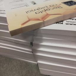 Powielarnia MADAS - Stos wydrukowanych kart z logo i tekstem 'Recepta na piękno!', widoczne detale druku i grubość papieru.