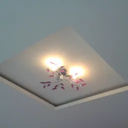 Biały sufit z wnęką i zamontowanym ozdobnym oświetleniem z elementami w kolorze fuksji.