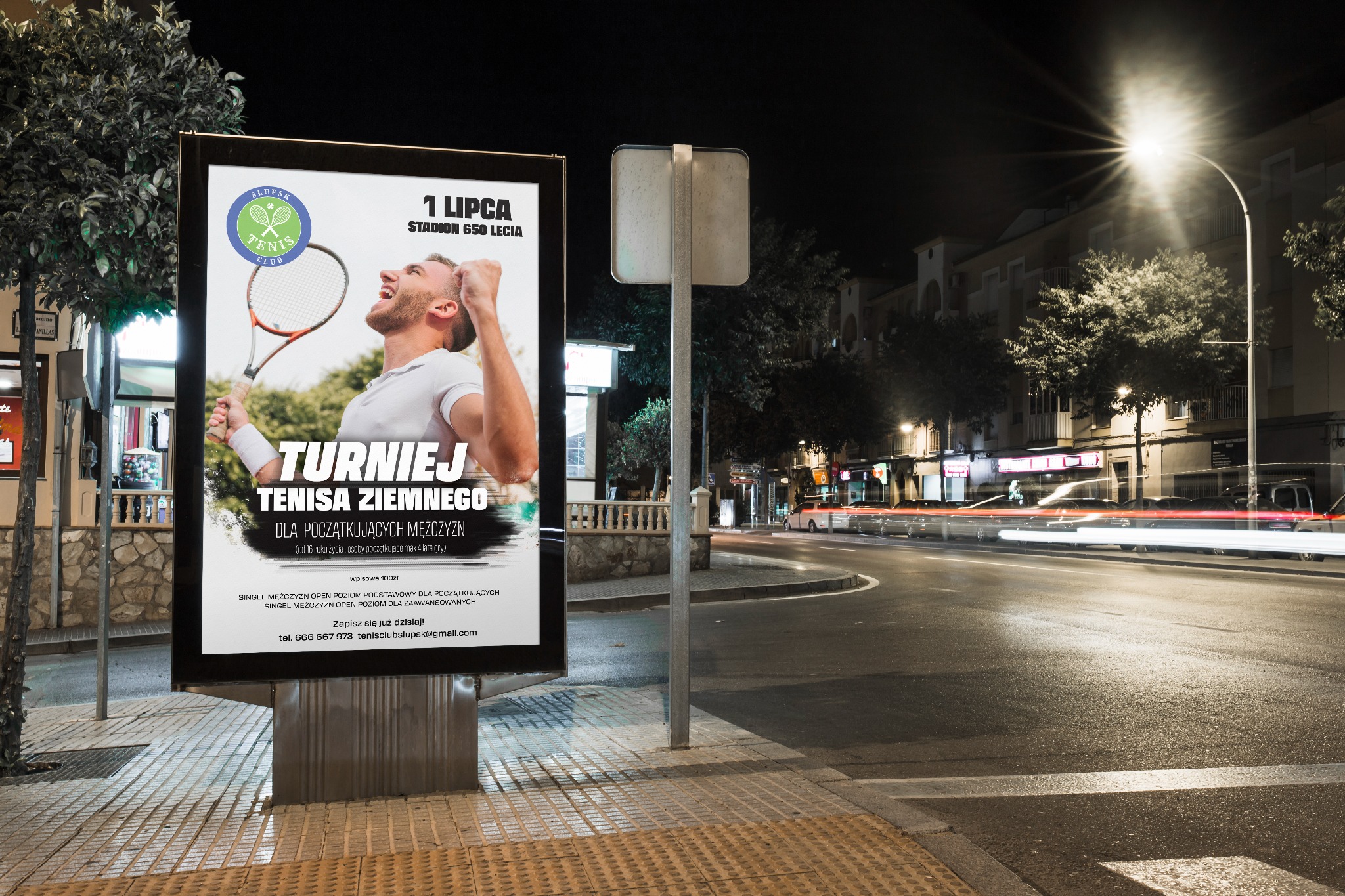 Podświetlany billboard reklamujący turniej tenisa ziemnego, umieszczony przy nocnej ulicy z rozmytymi światłami przejeżdżających samochodów.