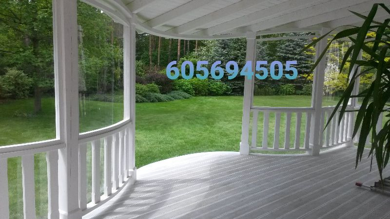 Wnętrze białej altany z widokiem na zielony ogród, numer telefonu naniesiony na obraz.