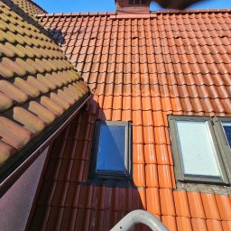 Wysokociśnieniowi Marcin Szczepanik - Czerwona dachówka po umyciu, widoczne okna dachowe i fragment drabiny. Część dachu po lewej stronie jest jeszcze zabrudzona, co uwidacznia efekt czyszczenia.