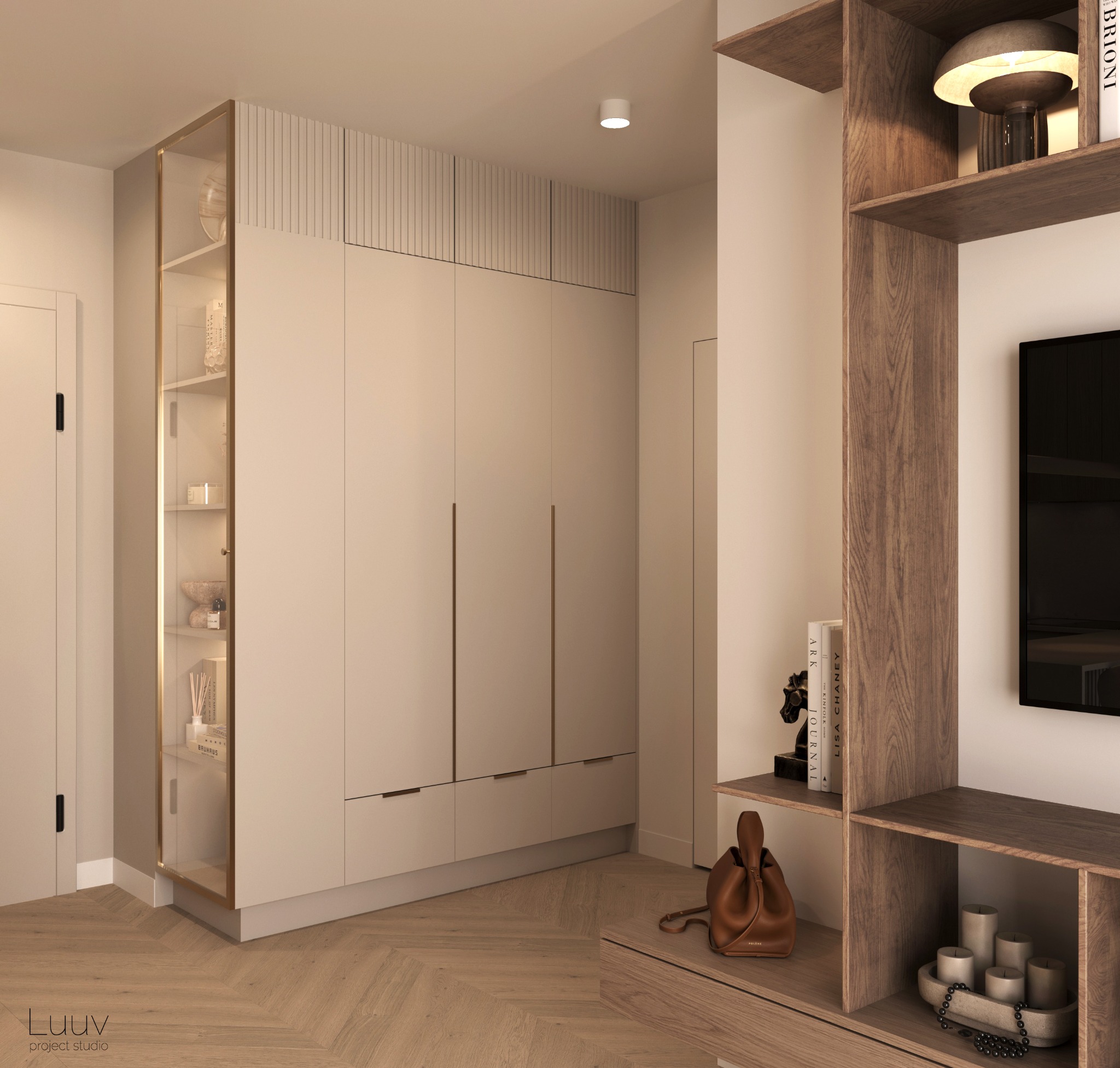 Wnętrze mieszkania w neutralnych barwach: zabudowa szaf z ryflowanym wykończeniem, przeszklona witryna z dekoracjami, drewniany regał z telewizorem, parkiet w jodełkę, skórzana torebka na półce.