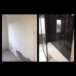 Łazienka w trakcie remontu: po lewej surowa ściana z instalacją wodną, po prawej kabina prysznicowa z czarnymi płytkami z złotymi żyłami i jasną podłogą.