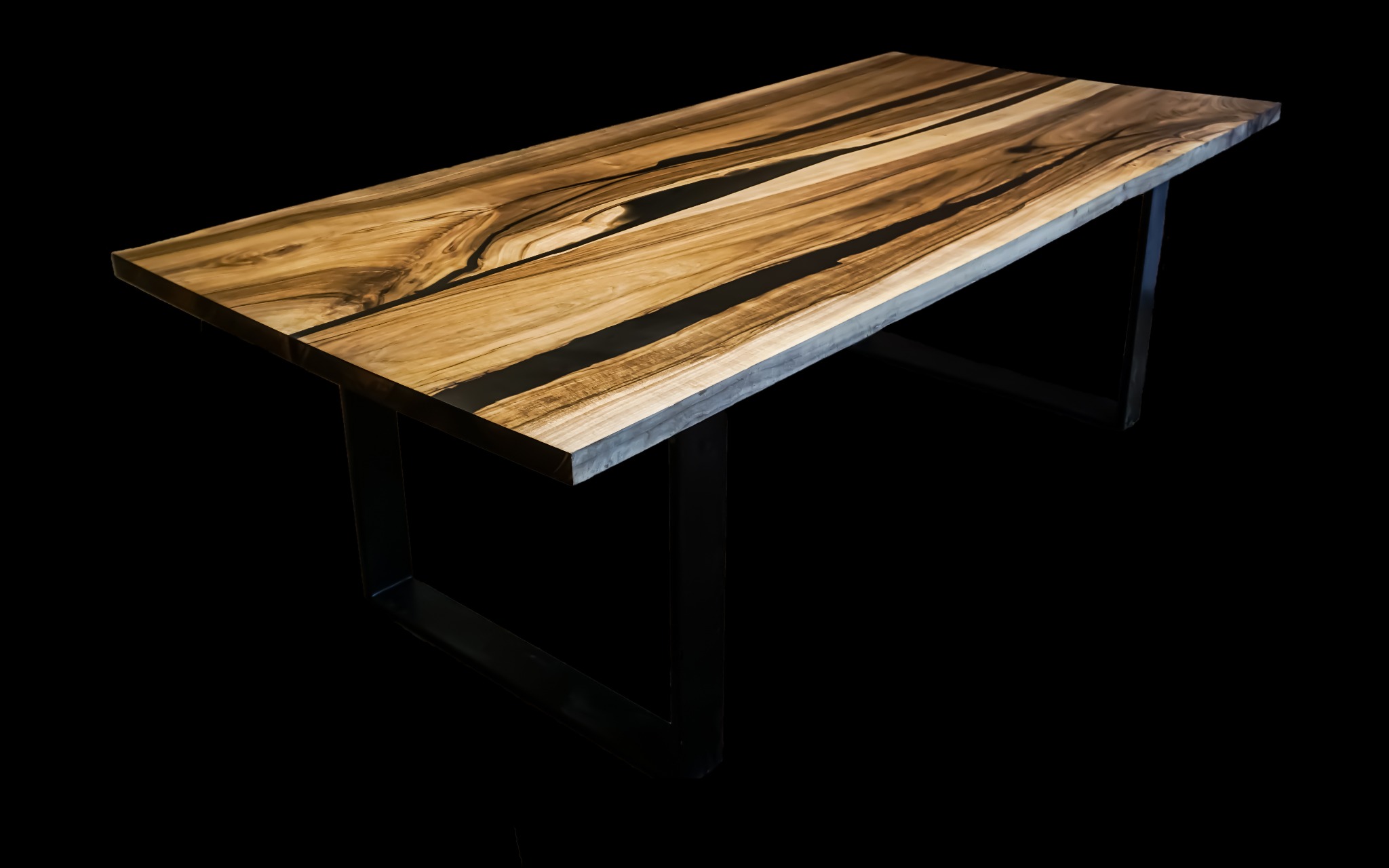 Stół z blatem z egzotycznego drewna z żywicą epoksydową w kolorze czarnym, osadzony na metalowych nogach w kształcie litery U, na czarnym tle.