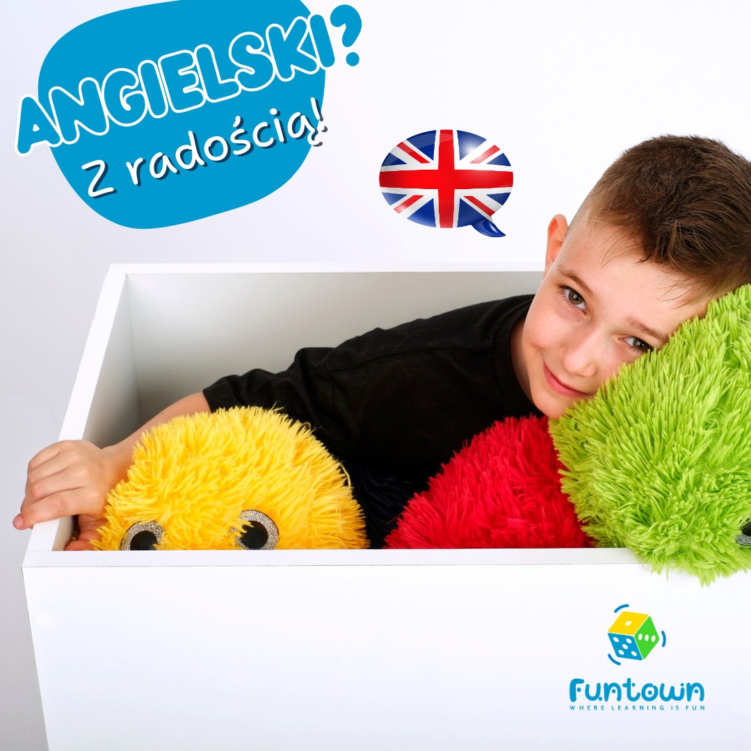 Uśmiechnięty chłopiec w czarnej koszulce, wystający z białego pudła z trzema kolorowymi pluszakami, nad nim napis 'Angielski? Z radością!' oraz flaga Wielkiej Brytanii w dymku, w prawym dolnym rogu...