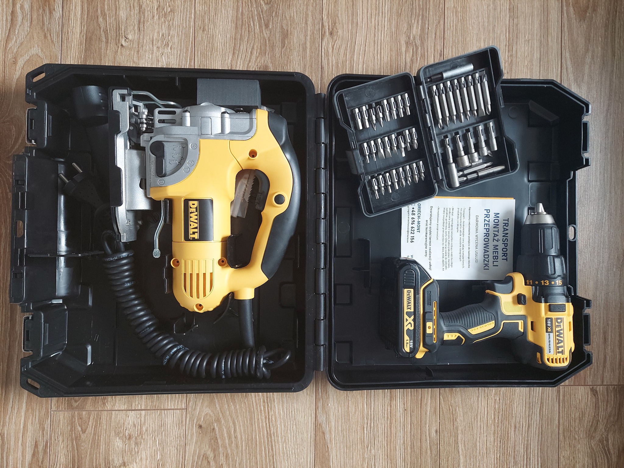 Zestaw narzędzi DeWalt w czarnej walizce: wyrzynarka, wkrętarka z akumulatorem i zestaw bitów, leżące na drewnianym podłożu.